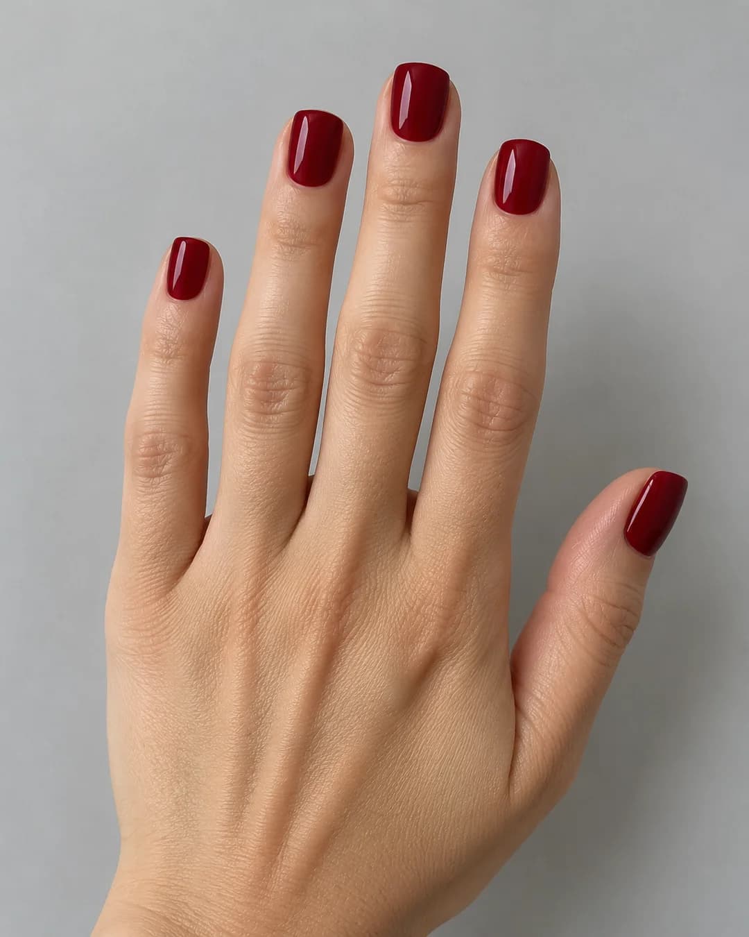 Uñas cortas squoval en granate liso brillante. Detalle de las uñas.