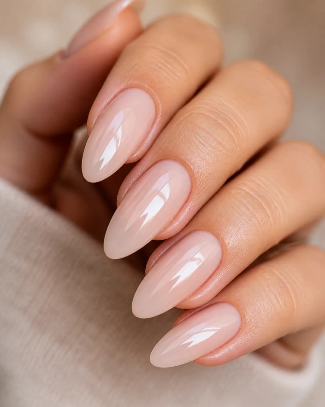 Uñas almendradas largas en nude lechoso con acabado glass