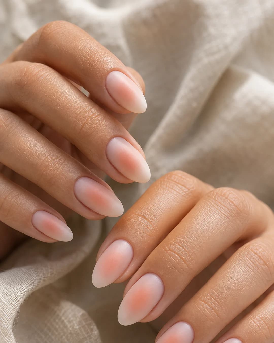 Uñas con efecto aura degradado circular melocotón sobre base lechosa