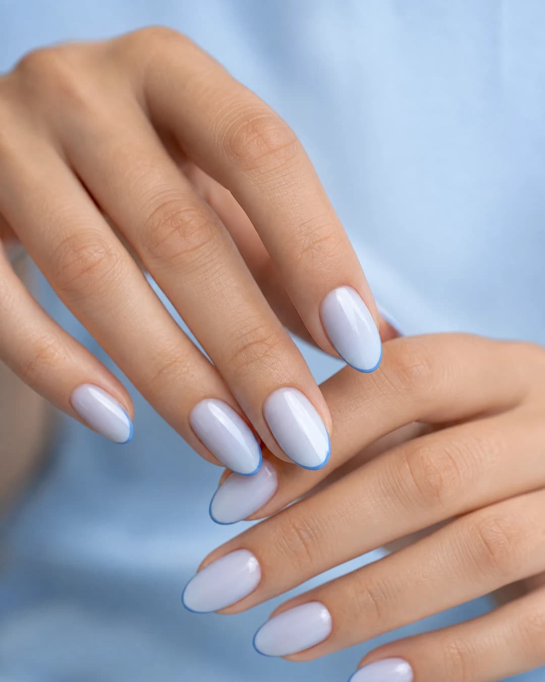 Uñas almendradas con blueberry milk azul lechoso translúcido y microline francesa en azul más saturado