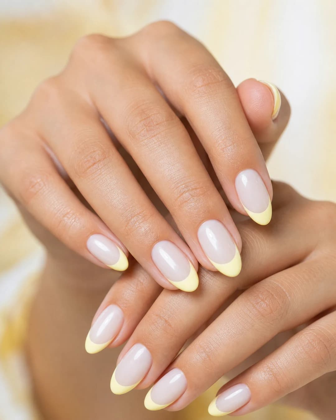 Uñas almendradas con francesa moderna en amarillo mantequilla pastel sobre base milky