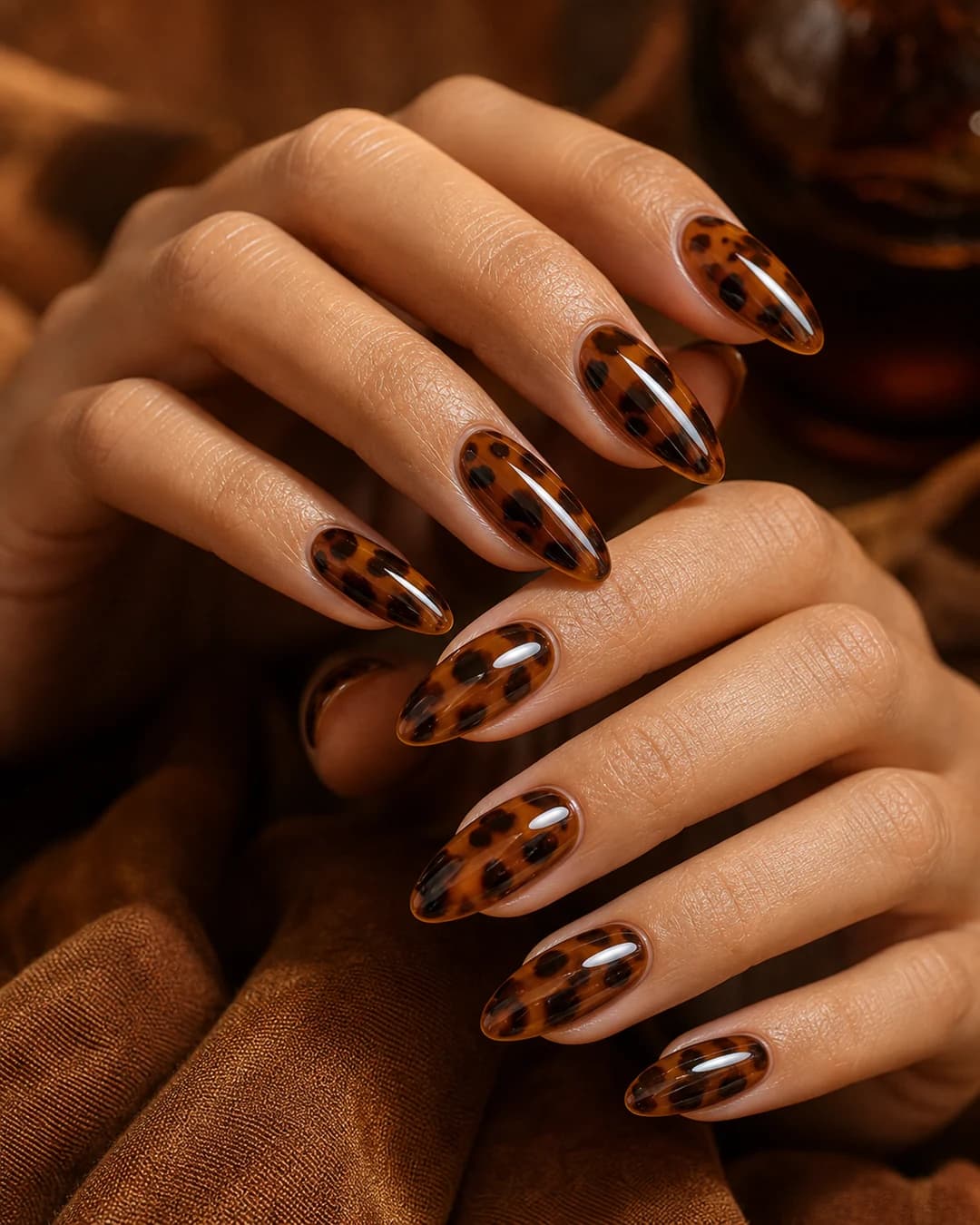 Uñas almendradas largas con patrón carey de chocolate medio sobre base ámbar y acentos negros