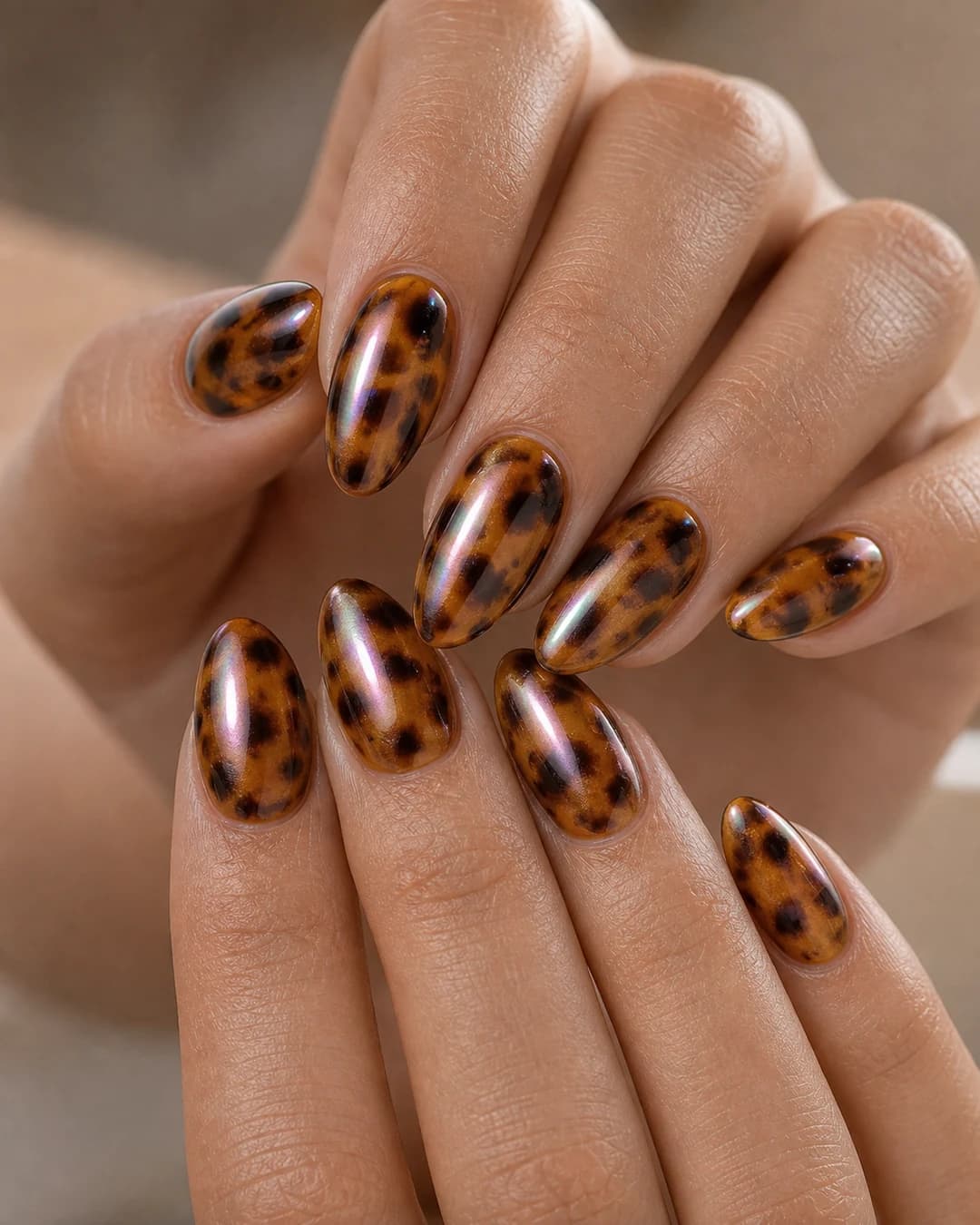 Uñas almendradas con base carey clásica y acabado glazed chrome sutil iridiscente