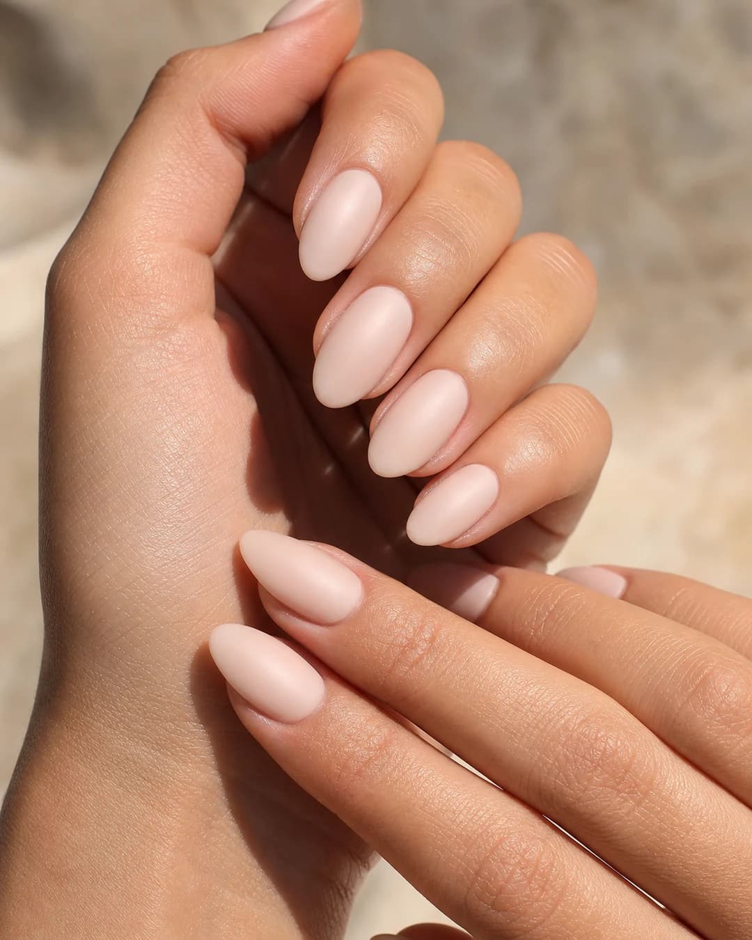 Uñas almendradas medias con dip powder en nude rosado opaco cremoso acabado satinado denso