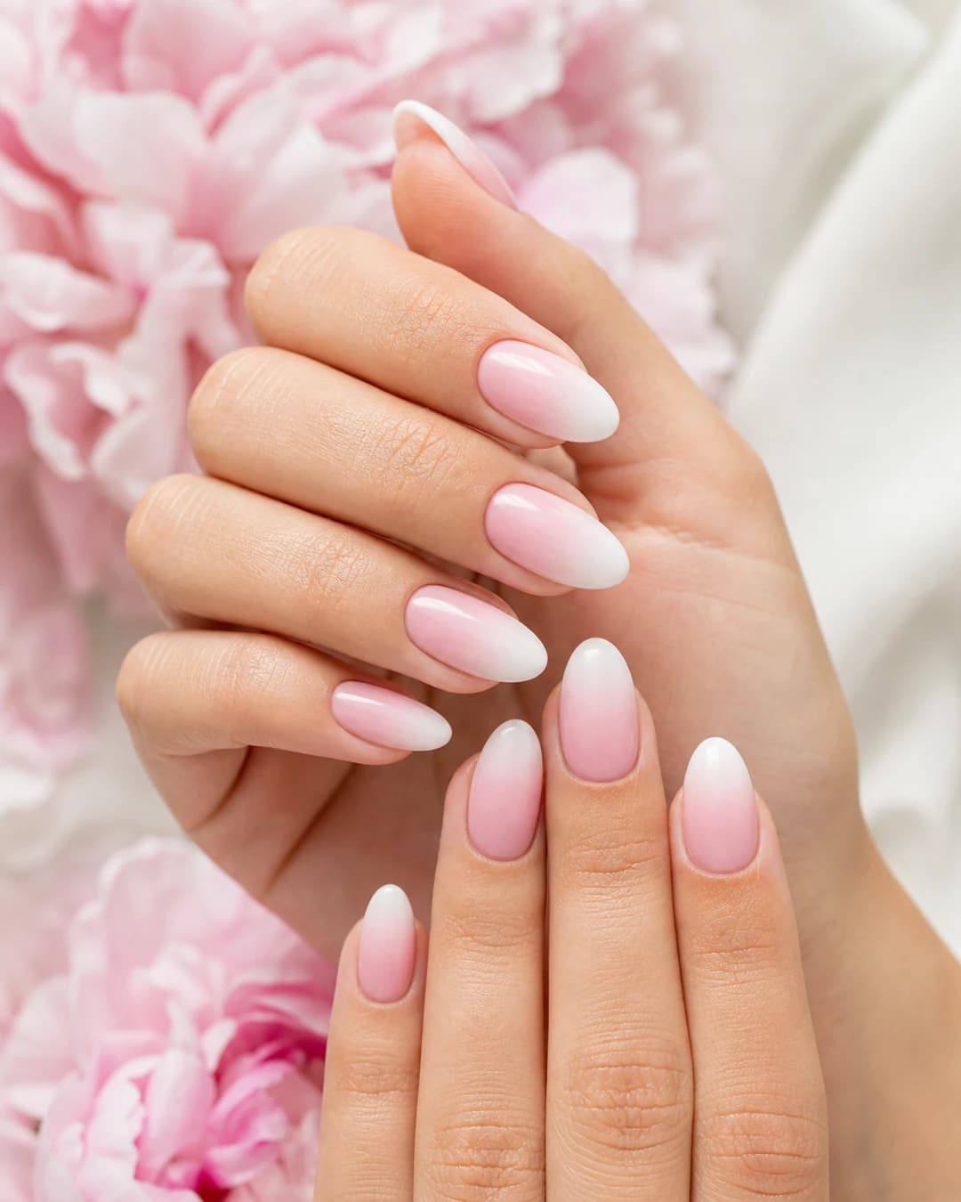 Uñas almendradas con dip powder en degradado ombre desde rosa palo hasta blanco roto