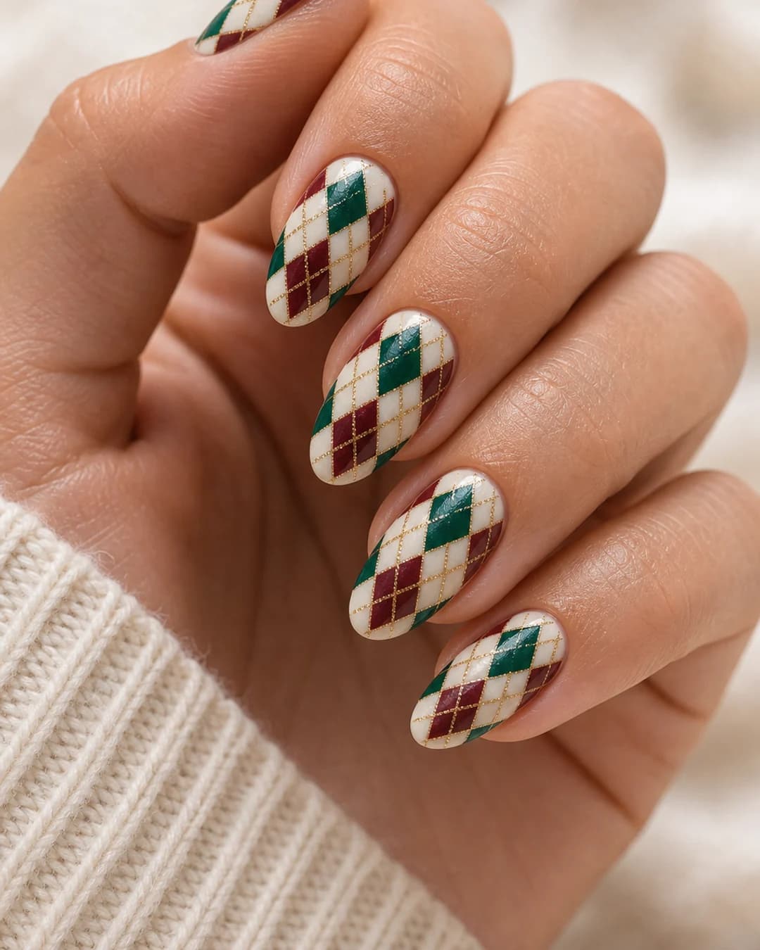 Uñas con estampado argyle de rombos en tonos joya esmeralda y granate sobre crema