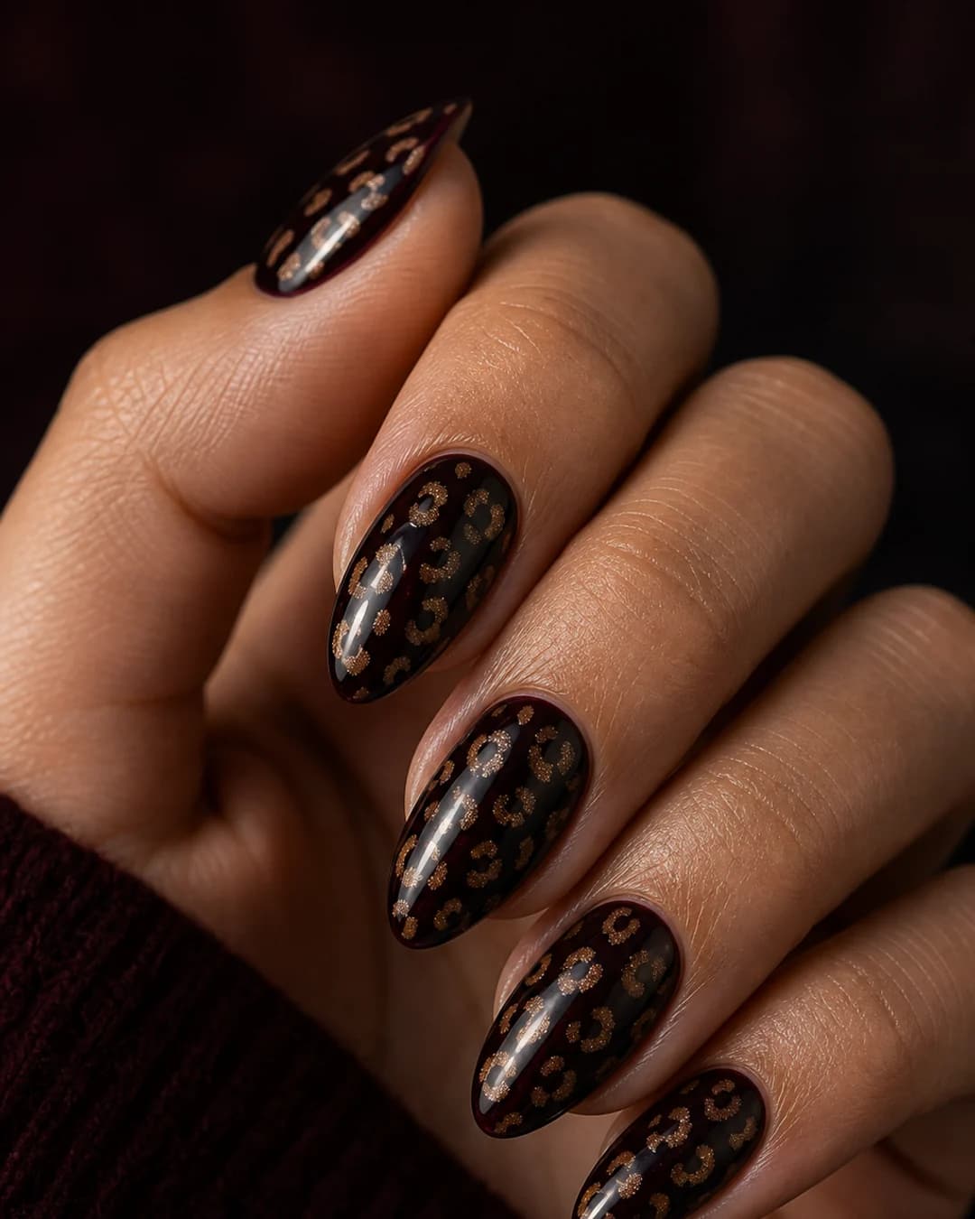Uñas con estampado leopardo discreto sobre base burdeos casi negro cherry oscuro