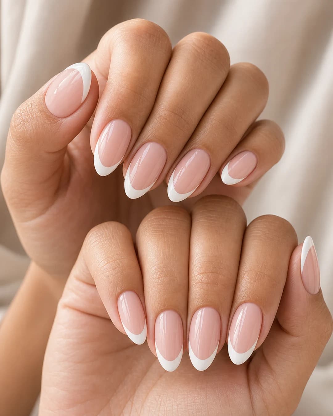 Manicura francesa clásica con punta blanca nítida sobre base nude rosado en uñas almendradas