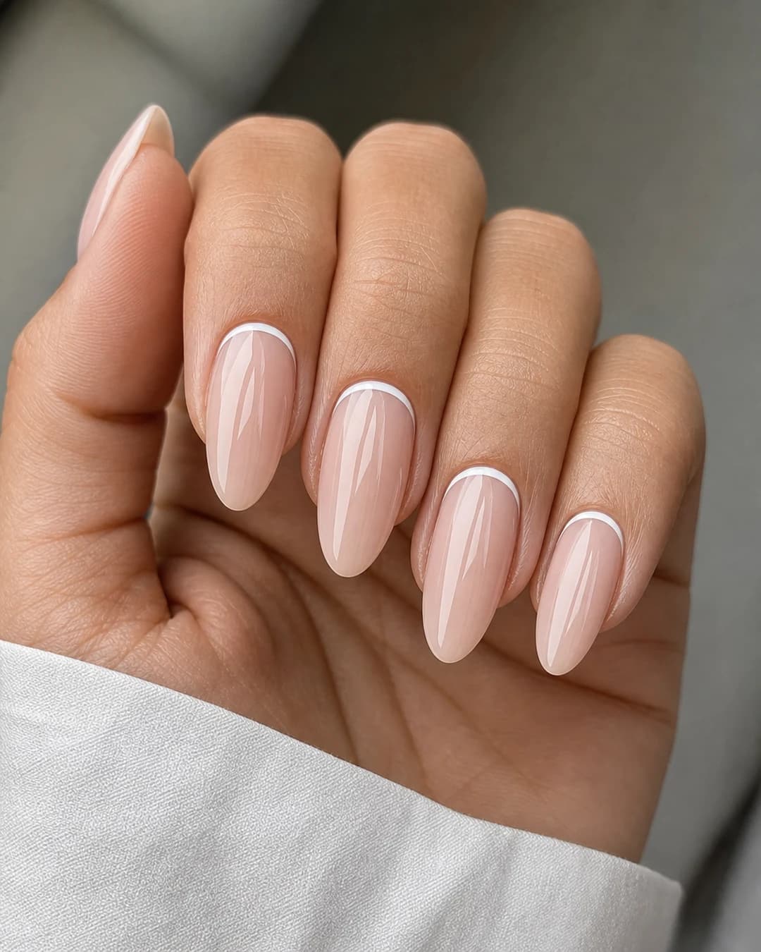 Manicura francesa invertida con línea blanca en la cutícula sobre base nude