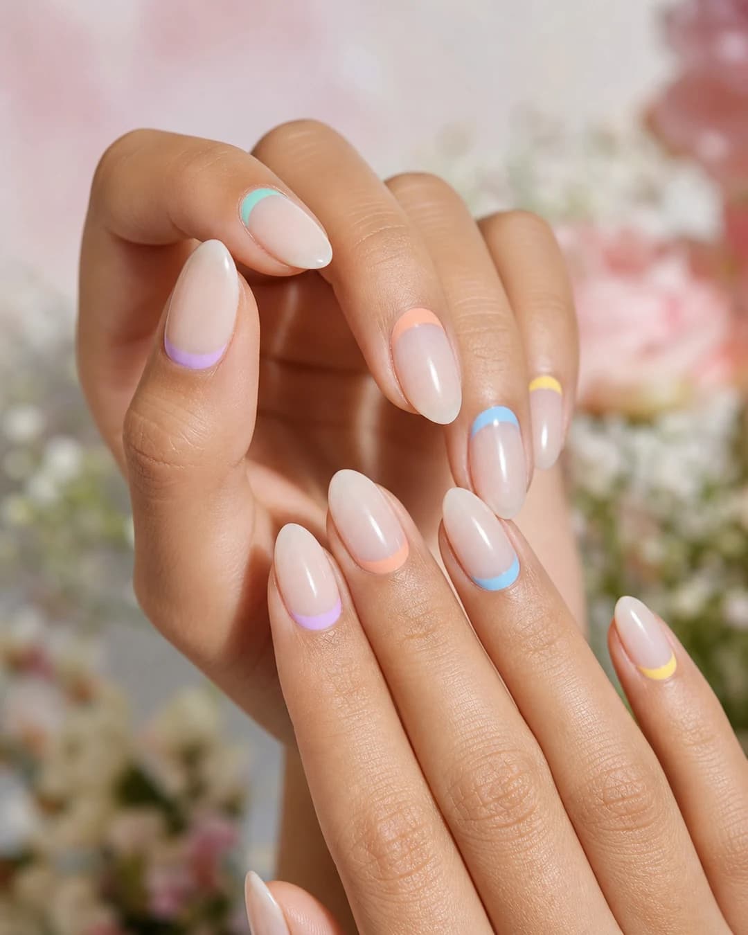 Uñas almendradas con francesa invertida en la cutícula cada uña con color distinto pastel