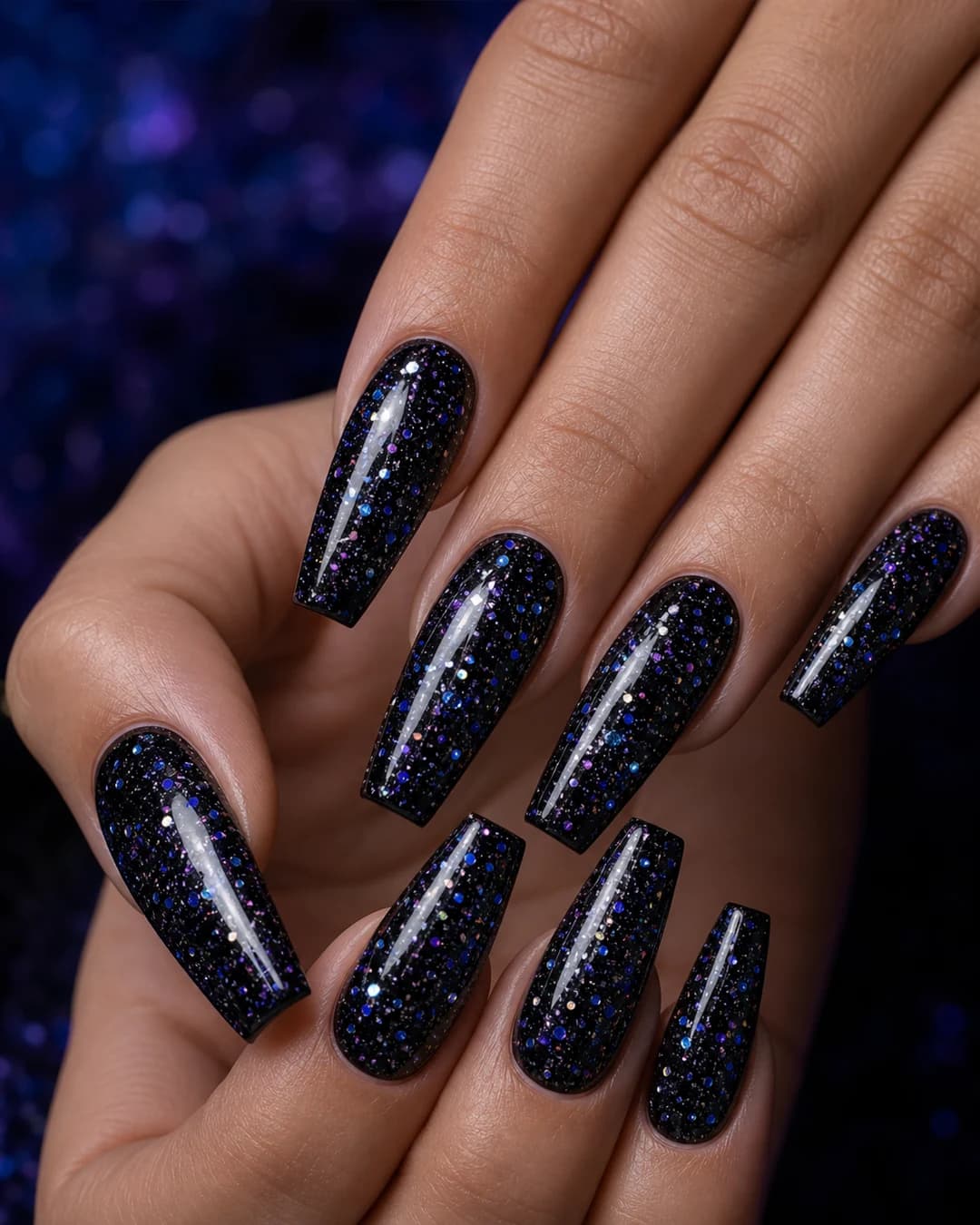 Uñas coffin negras con glitter multicolor disperso simulando galaxia espacial