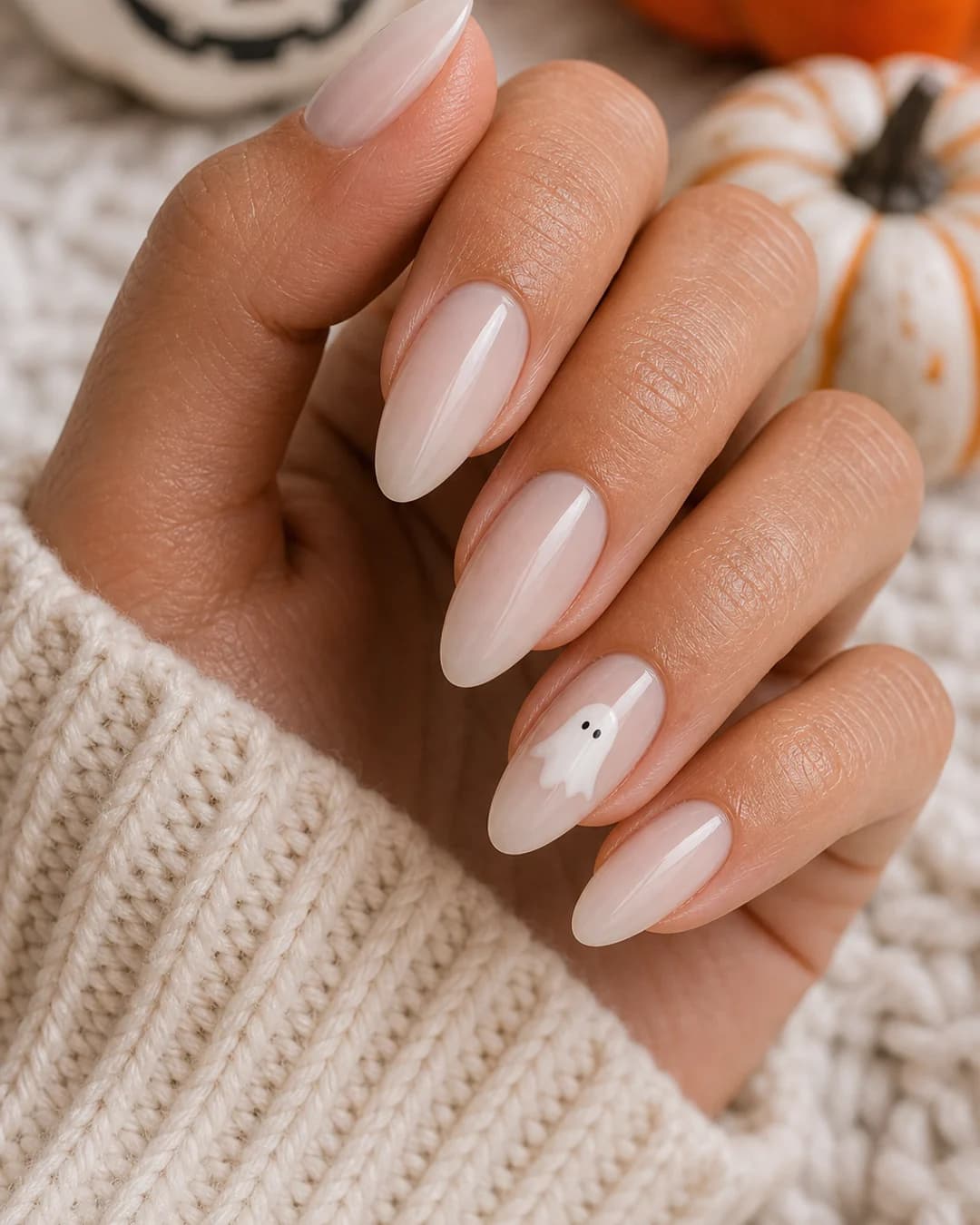 Uñas lechosas con un fantasma blanco kawaii pintado en el anular Halloween