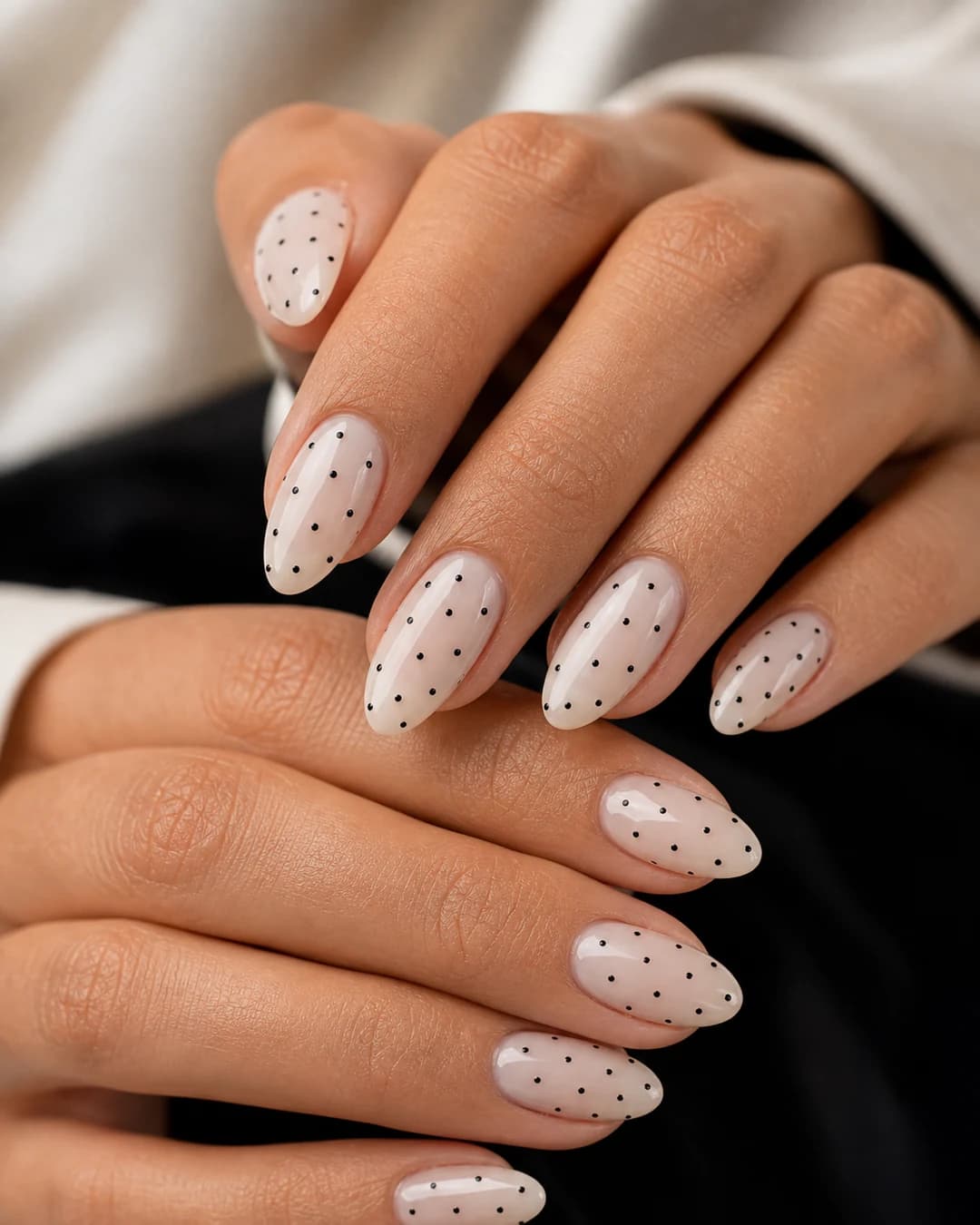 Uñas milky lechosas con micro polka dots negros scattered