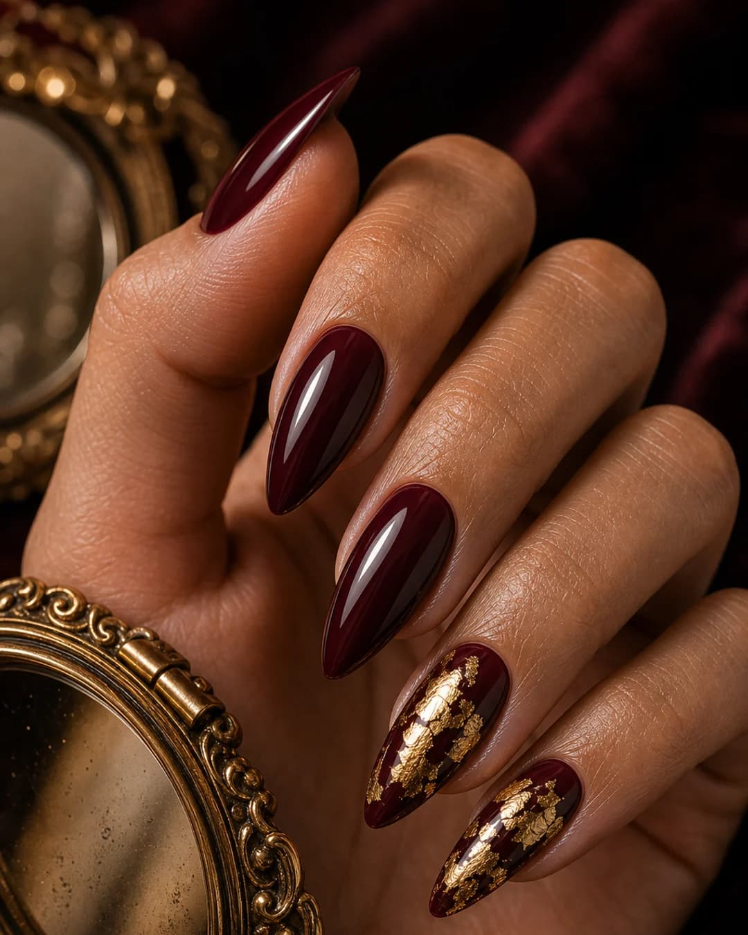 Uñas burdeos con pan de oro vintage en el anular y meñique mob wife