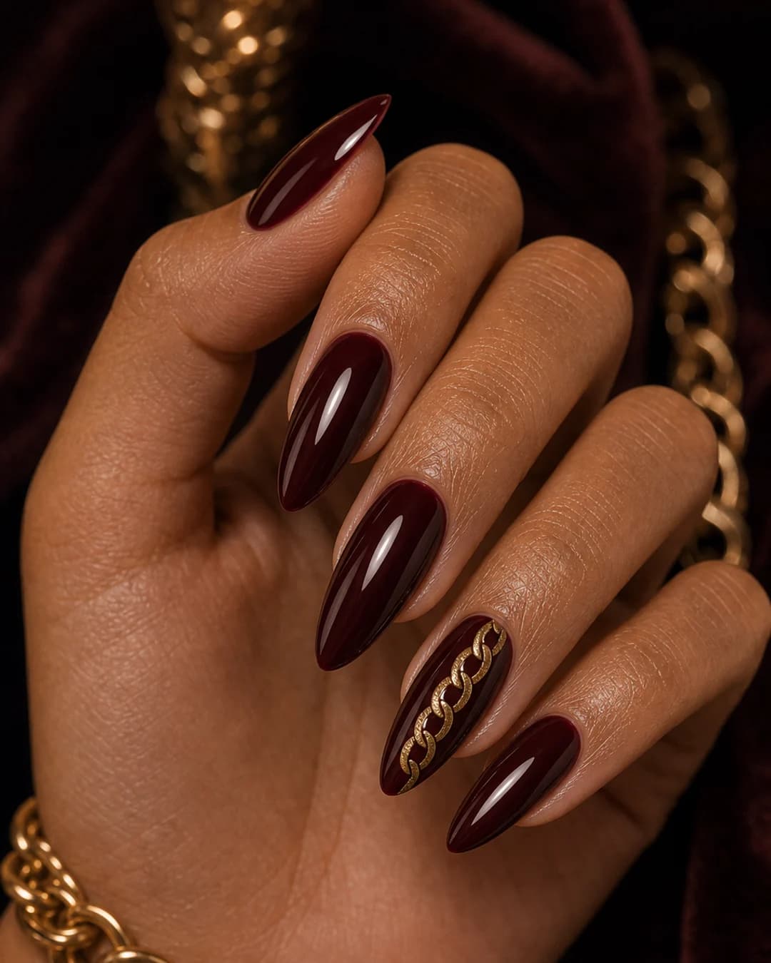 Uñas oxblood con cadena de oro vintage pintada en el anular mob wife