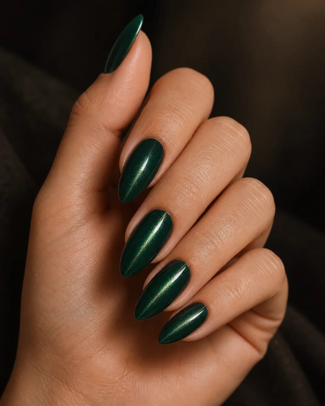 Uñas almendradas en verde esmeralda con efecto ojo de gato magnético