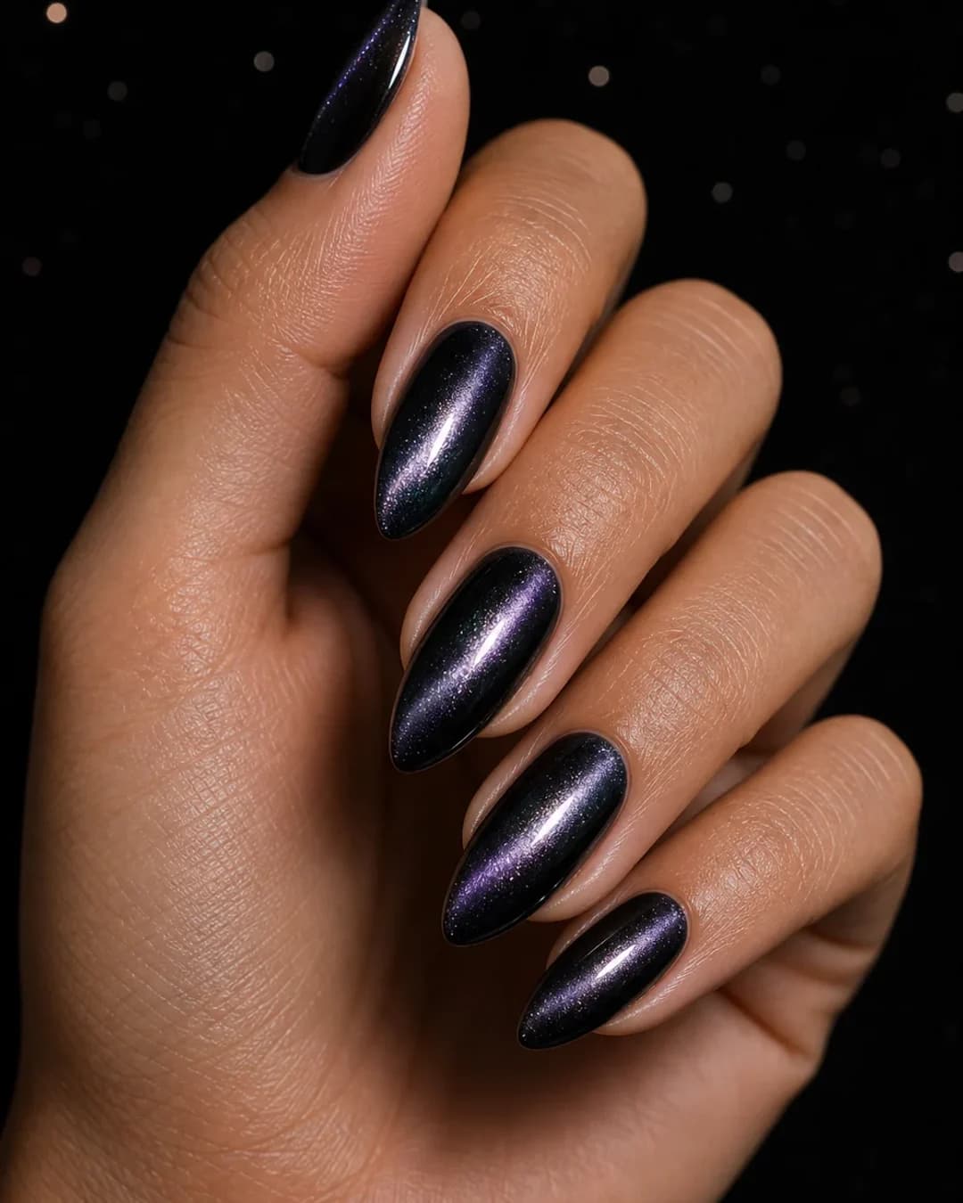 Uñas almendradas en negro con destello plata holográfico tipo galaxia