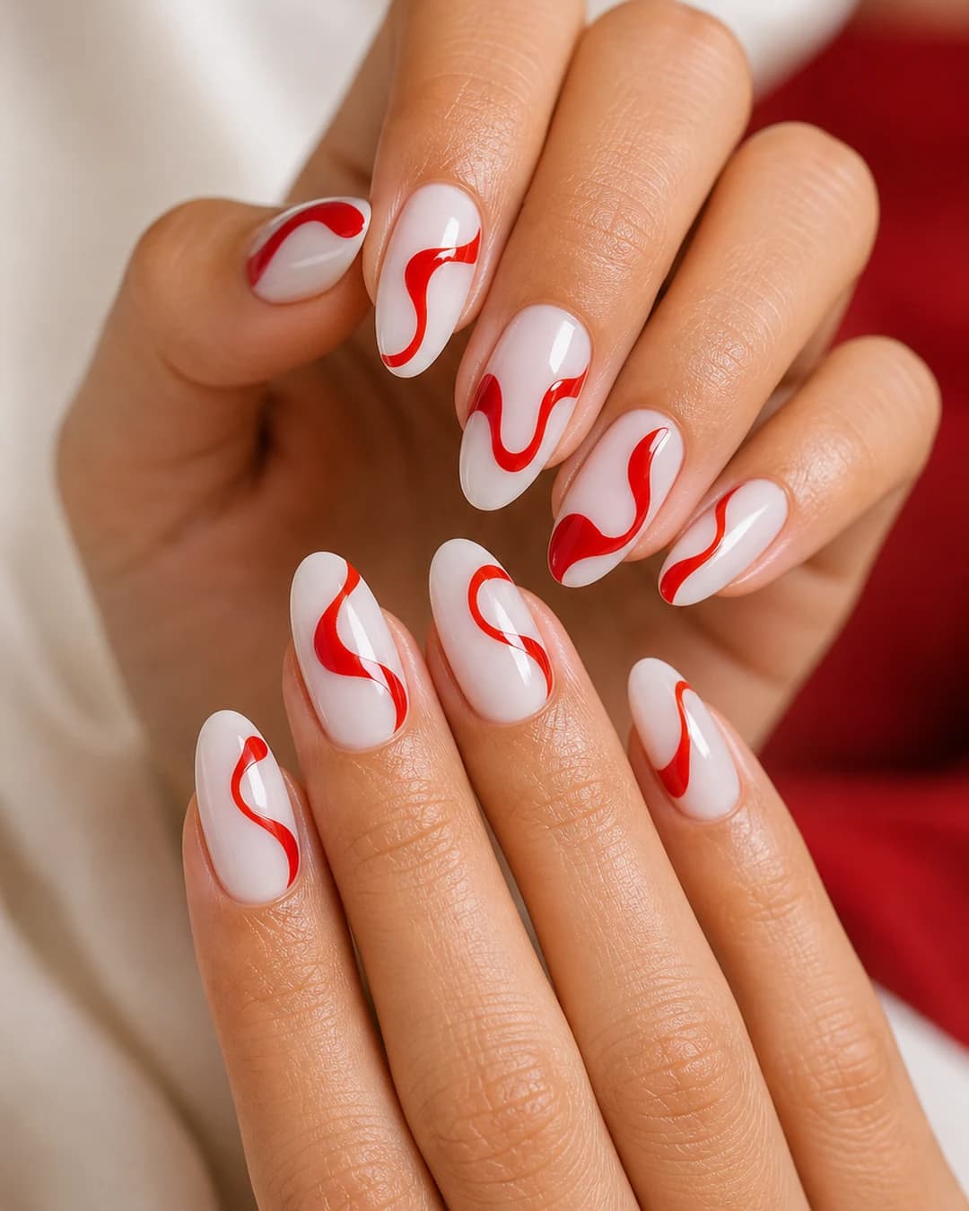Uñas swirl con remolinos cherry red sobre base milky lechosa