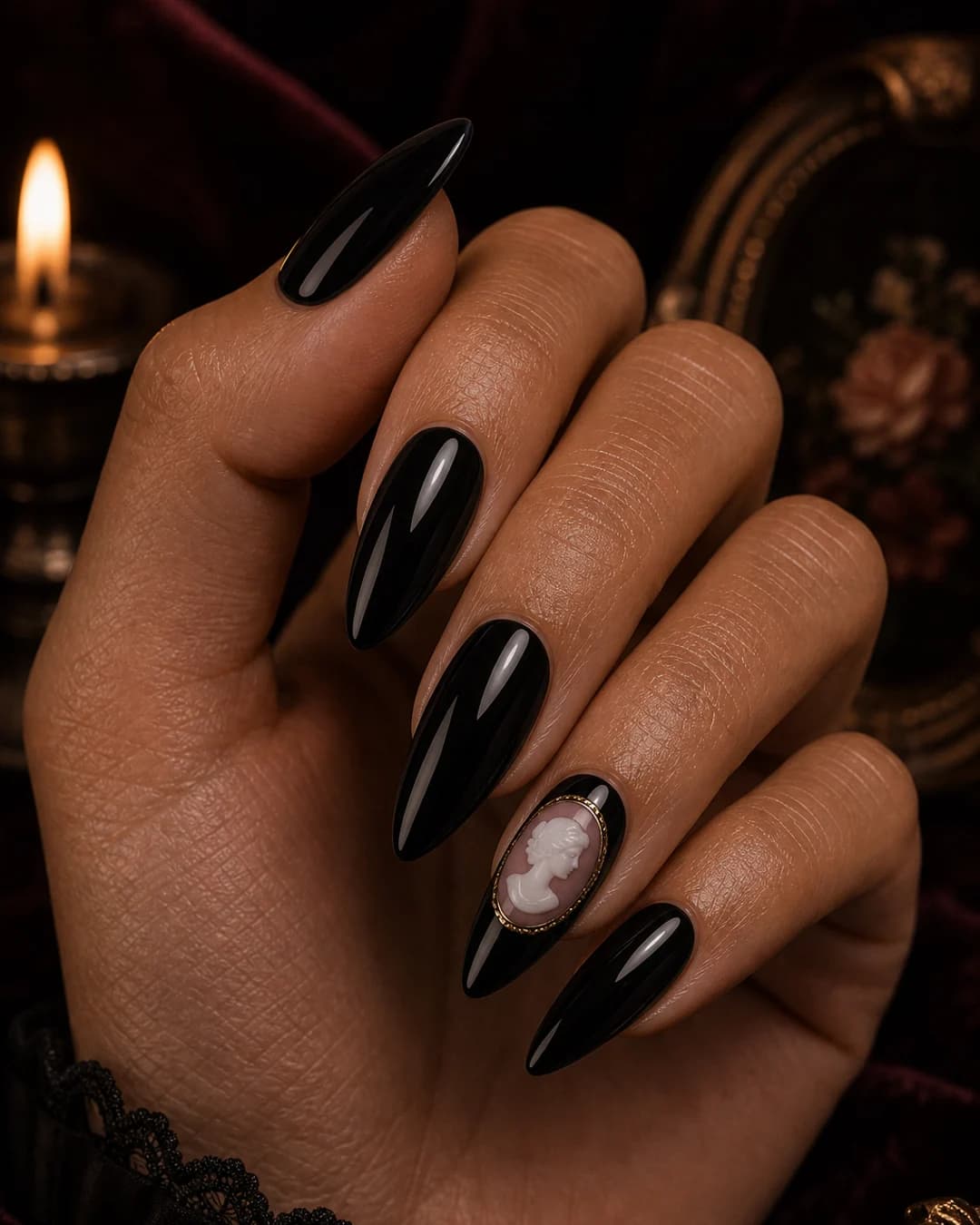 Uñas negras con un mini cameo blanco-rosa vintage pintado en el anular