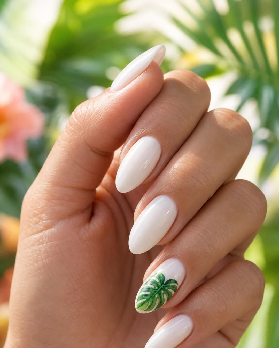 Uñas blancas con una micro hoja verde tropical pintada a mano en el anular