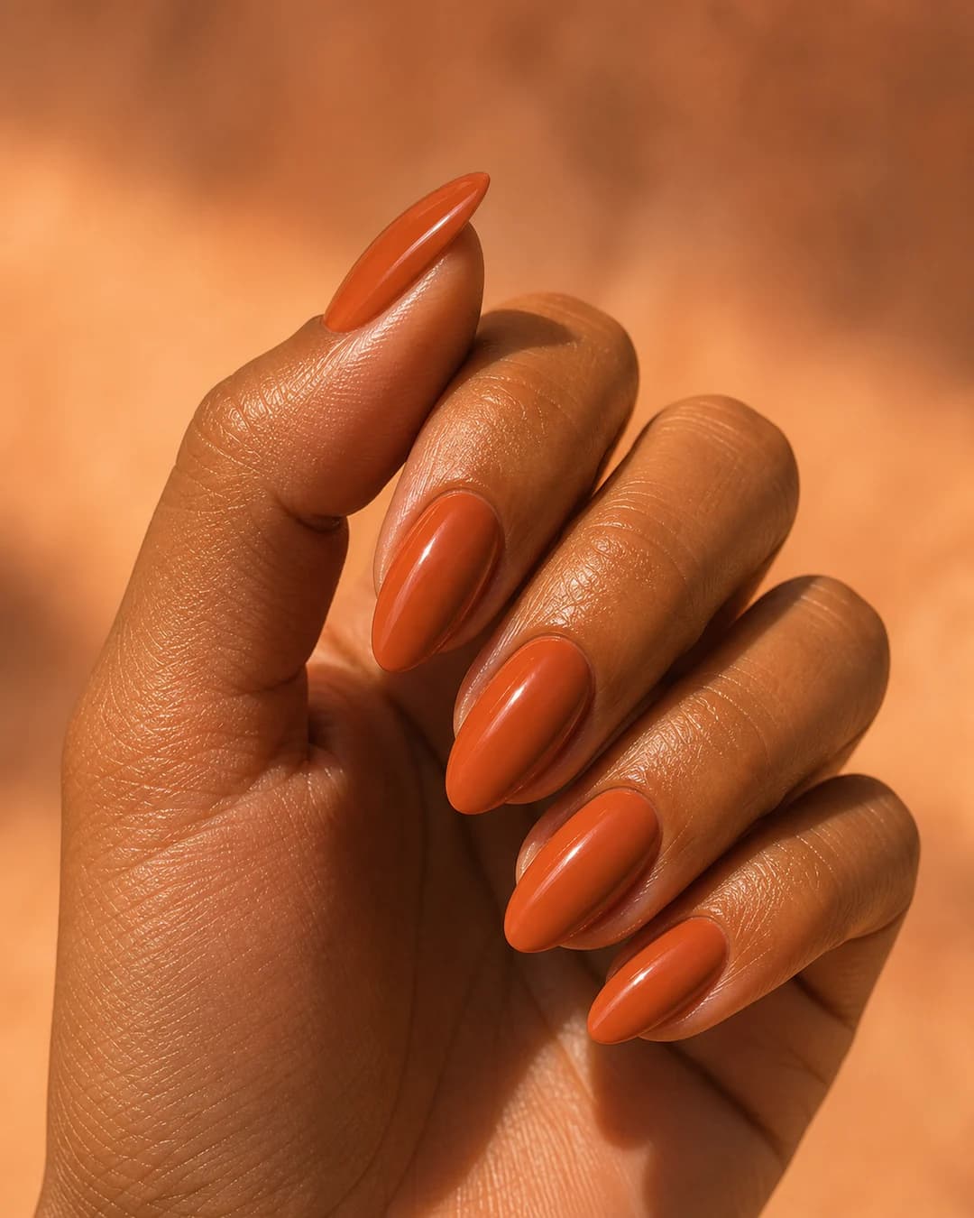 Uñas almendradas en naranja terracota cálido para verano