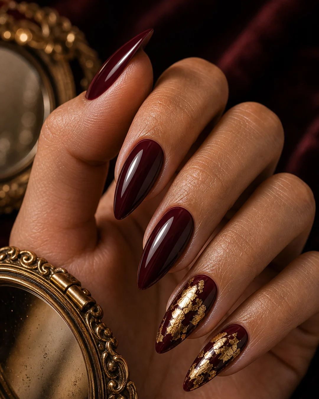 Uñas burdeos con pan de oro vintage en el anular y meñique mob wife