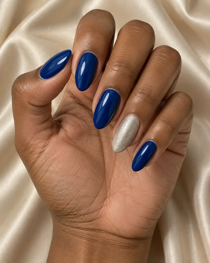 Uñas azules con una uña plateada de acento.