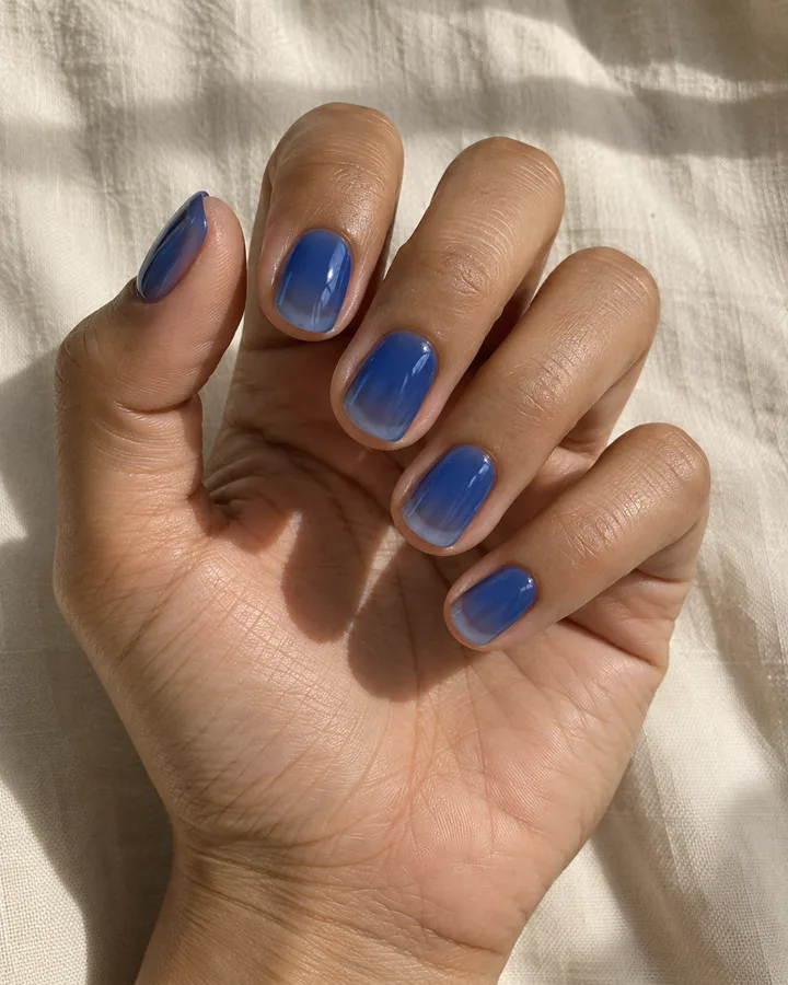 Uñas redondeadas con esmalte azul jelly translúcido.